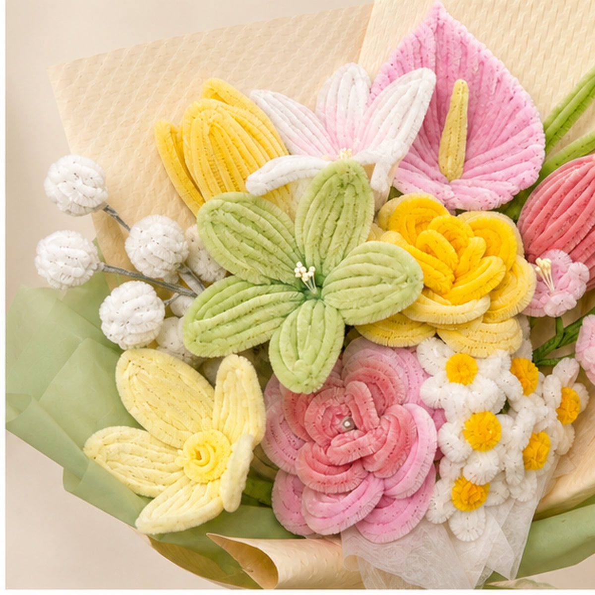 Close-up of the Enchanted Garden handmade chenille bouquet, showing textured pastel pink, yellow, green and ivory flowers.