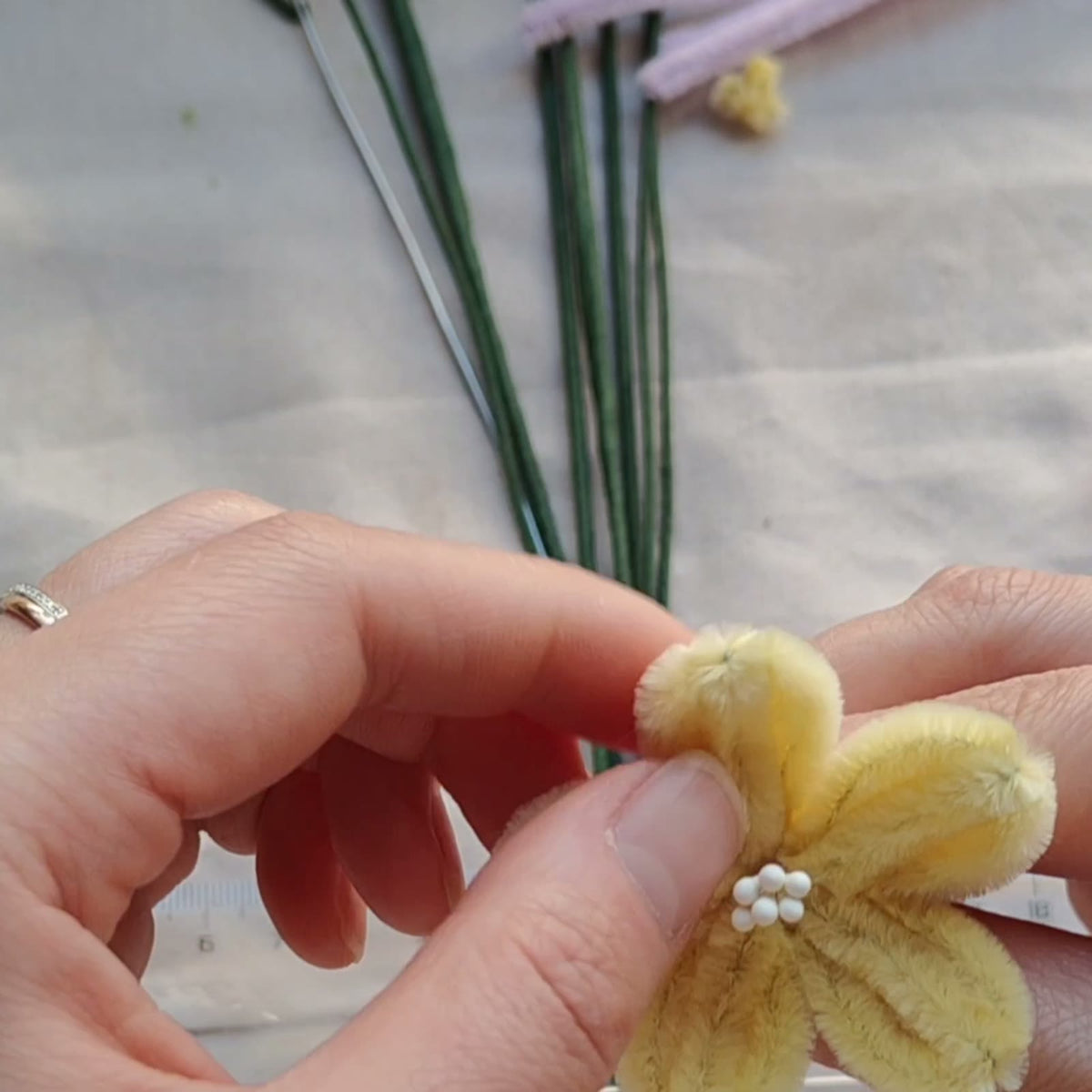 Small yellow chenille flower shown in the assembly lesson